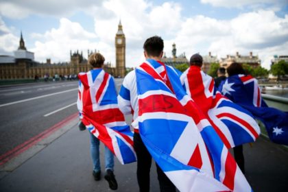 People walk over Westminster Bridge wrapped in Union flags, towards the Queen Elizabeth To