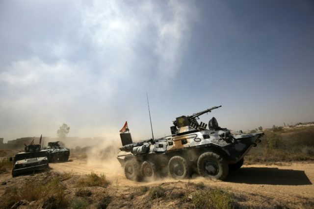 Iraqi government forces drive their armoured vehicles during an operation in Fallujah's so