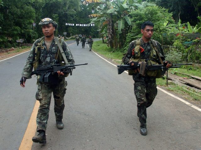 Philippine marines patrol a highway on the southern island of Mindanao as they continue th