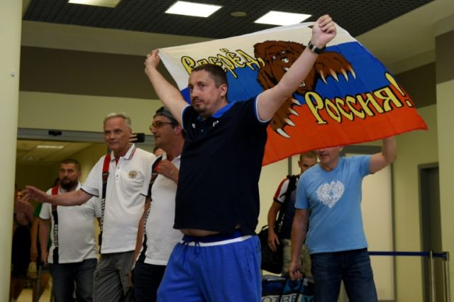 Russian football fan leader Alexander Shprygin holds a flag at Sheremetevo airport near Mo