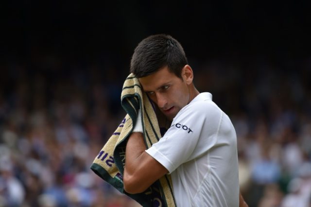 Novak Djokovic wipes his face with a towel during his men's singles final match against Ro