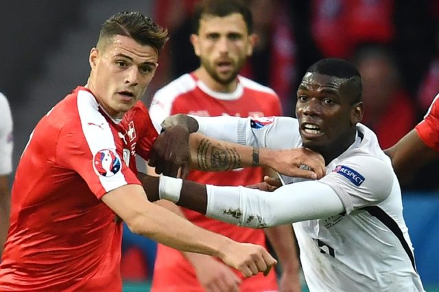 Switzerland's Granit Xhaka (L) fights for the ball with France's Paul Pogba during their E