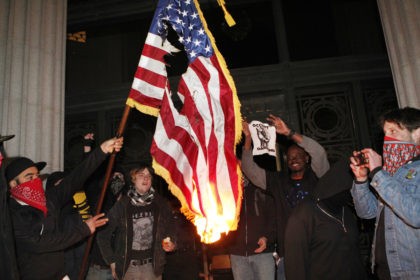In this Saturday, Jan. 28, 2012 file photo, Occupy Oakland protesters burn a U.S. flag fou