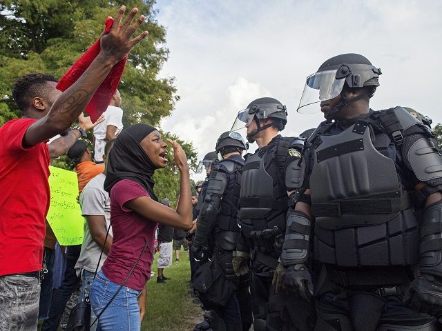 A protester yells at police officers in riot gear after being forced off the motor way in front of the the Baton Rouge Police Department Headquarters in Baton Rouge, La., Saturday, July 9, 2016. Several hundred protesters, including members of the New Black Panther party, blocked the road causing police …