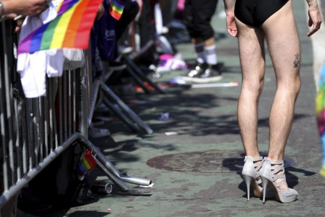 A man wears very tall and sparkling high heel shoes while participating in the NYC Pride P