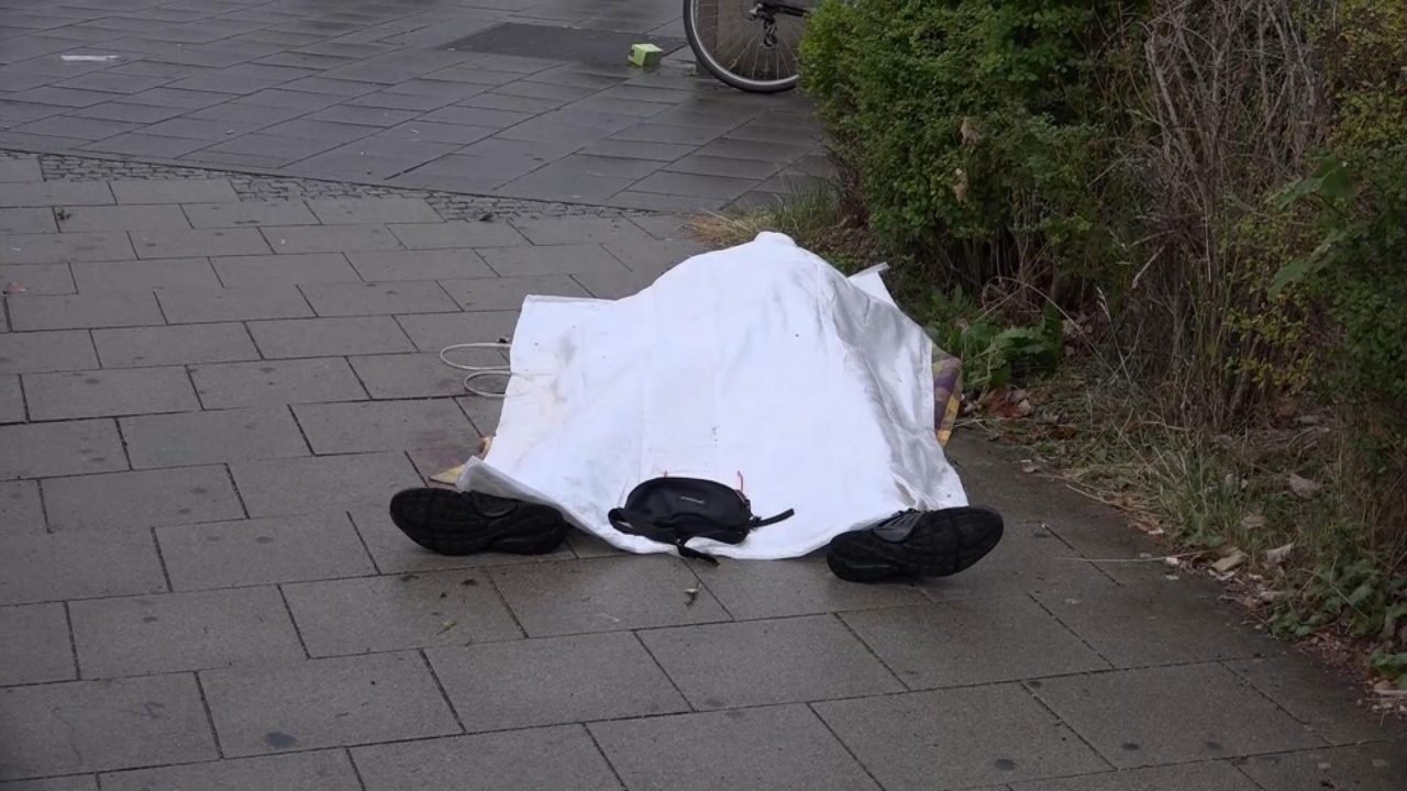 GERMANY OUT In this grab taken from video, a body covered with a sheet outside a mall, in Munich, Germany, Friday, July 22, 2016. A manhunt was underway Friday for a shooter or shooters who opened fire at a shopping mall in Munich, killing and wounding several people, a Munich police spokeswoman said. The city transit system shut down and police asked people to avoid public places. (NONSTOP NEWS via AP)