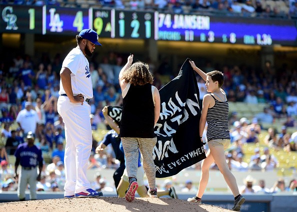 LOS ANGELES, CA - JULY 03: Protestors interupt the game as Kenley Jansen #74 of the Los Angeles Dodgers waits on the mound during the ninth inning against the Colorado Rockies at Dodger Stadium on July 3, 2016 in Los Angeles, California. (Photo by Harry How/Getty Images)