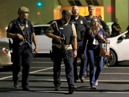 Dallas police officers escort a woman near the scene where eleven Dallas police officers were shot and five have now died on July 8, 2016 in Dallas, Texas)