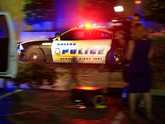 Dallas police officer drives near the scene where eleven Dallas police officers were shot