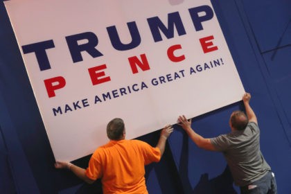 CLEVELAND, OH - JULY 17: Workers hang campaign signs in the Quicken Loans Arena a day bef