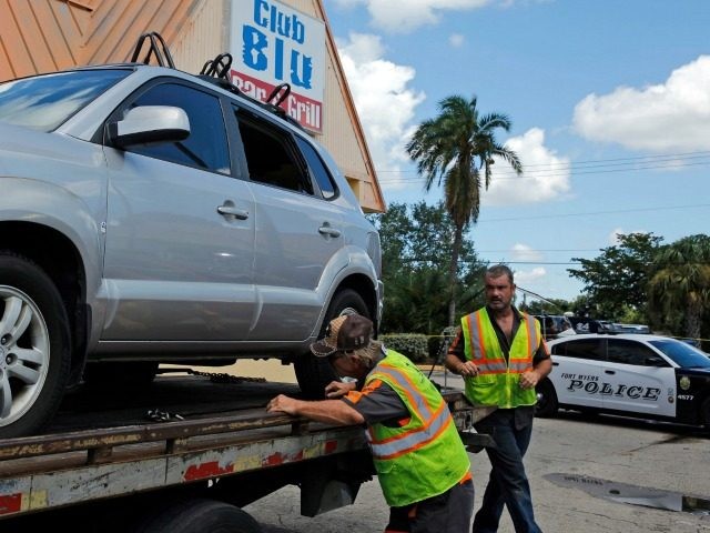 GettyImages-580021258 FORT MYERS, FL - JULY 25: Police remove a car hit by gunfire outside of Club Blu where two
