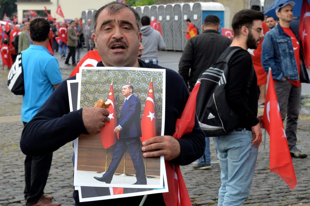 COLOGNE, GERMANY - JULY 31: Supporters of Turkish President Recep Tayyip Erdogan rally at a gathering on July 31, 2016 in Cologne, Germany. Cologne and surrounding cities are home to tens of thousands of people of Turkish descent. Erdogan has pursued strong-handed measures following the recent coup attempt by elements of the Turkish armed forces that include the shuttering of media outlets and the arrest of journalists as well as suspensions of ten of thousands of university professors, public servants and police members. (Photo by Sascha Steinbach/Getty Images)