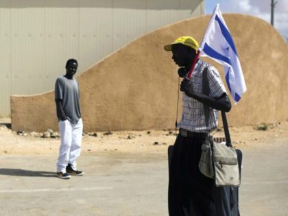 An African migrant holds an Israeli flag after being released from the Holot detention center in the Negev. (photo credit:REUTERS)