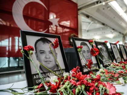 This picture taken on June 30, 2016 shows cloves left by airport employees next to killed airport employees pictures at Ataturk airport international terminal in Istanbul on June 30, 2016 two days after the triple suicide bombing and gun attack occurred at Istanbul's Ataturk airport.