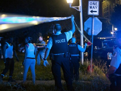 Members of the Chicago Police Department put up tape and clear the scene of a fatal shooti