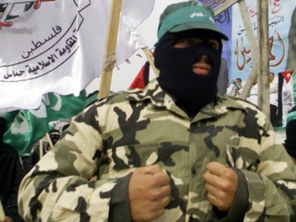 Militants from the radical Islamic group Hamas, jog during a rally past an effigy of Israeli Defence Minister Shaul Mofaz, hanging at a makeshift gallows in the northern West Bank town of Jenin, 27 March 2004.