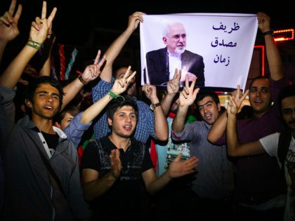 FILE -- In this July 14, 2015 file photo, young Iranian men cheer and show victory signs w
