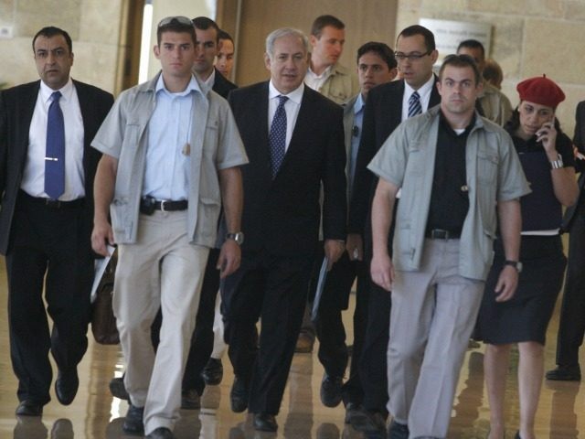 sraeli Prime Minister Benjamin Netanyahu (C) is flanked by bodyguards and unidentified aid