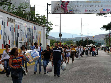 Venezuelans carrying groceries cross the Simon Bolivar bridge from Cucuta in Colombia back