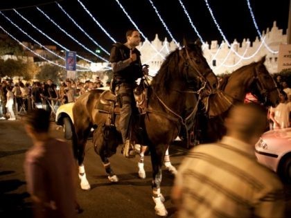 Horse mounted policemen stand guard under lights decorating the Damascus Gateon during the Muslim holy fasting month of Ramadan on August 8, 2011, at the old city of Jerusalem, Israel. (Photo by Uriel Sinai/Getty Images)