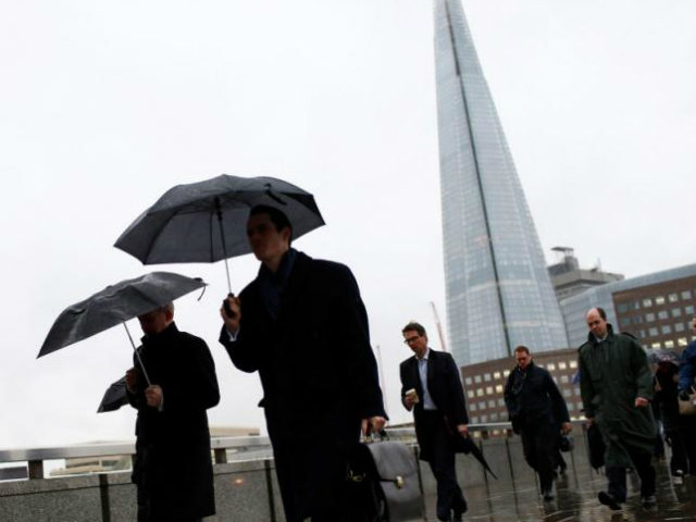 The Shard is seen as workers use umbrellas to shelter …