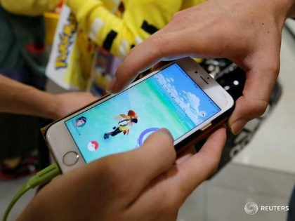 Men play the augmented reality mobile game ''Pokemon Go'' by Nintendo on a mobile phone in Tokyo, Japan July 22, 2016. REUTERS/TORU HANAI - RTSJ4LO