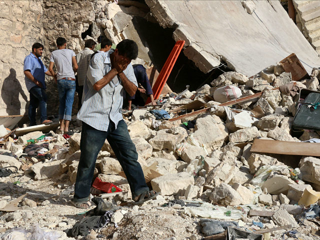 A Syrian man reacts as rescuers look for victims under the rubble of a collapsed building