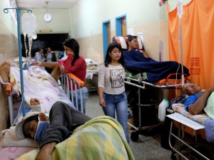 Patients lie on beds in an aisle of the emergency room at the Universitary Hospital in Mer