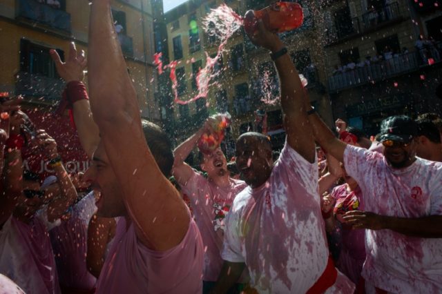 People throw wine during the 'Chupinazo' (start rocket) marking the kickoff of the San Fer