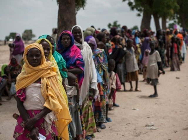 Women and children wait on June 30, 2016, to visit one of the UNICEF nutrition clinics, on