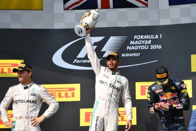 Mercedes driver Lewis Hamilton (C) celebrates his victory on the podium with second-placed