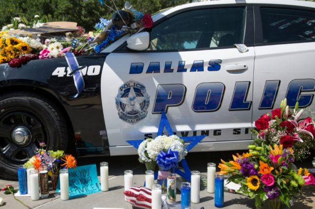 Flowers and candles adorn a memorial outside the Dallas Police Headquarters on July 8, 201