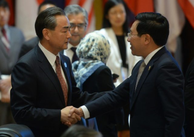 China's Foreign Minister Wang Yi (L) shakes hands with Vietnam's Foreign Minister Pham Bin
