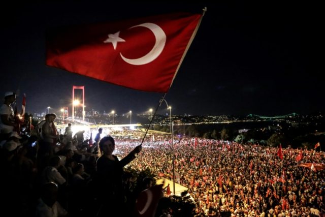 Pro-Erdogan supporters wave a Turkish national flag during a rally at the Bosphorus bridge