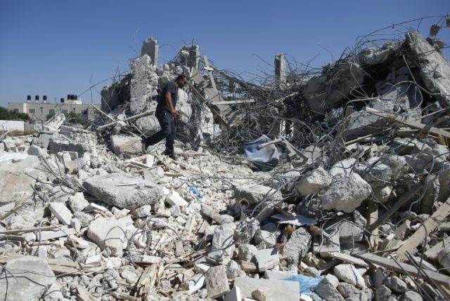 A Palestinian man walks atop the rubble of a house that was demolished by Israeli army bul