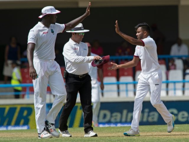 West Indies player Devendra Bishoo (R) celebrates on day one of the cricket Test match bet