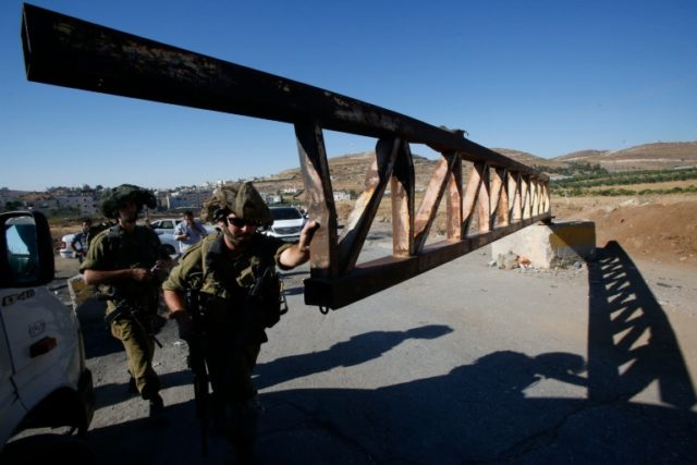 Israeli soldiers open a barrier blocking access to the al-Fawwar refugee camp, south of th