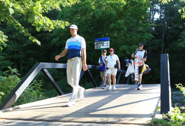 Dustin Johnson of the US walks over a bridge on his way to 12th tee during the second roun