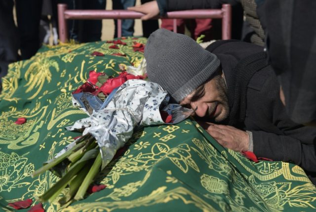 An Afghan relative reacts alongside the body of Saeed Jawad Hossini, 29, who was killed in