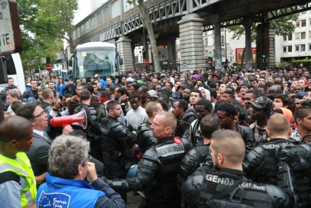 Police evict between 1,200 and 1,400 migrants from a makeshift camp in Paris on July 22, 2
