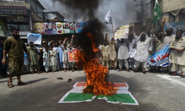Pakistani supporters of banned organisation Jamaat-ud-Dawa (JuD) shout slogans alongside b