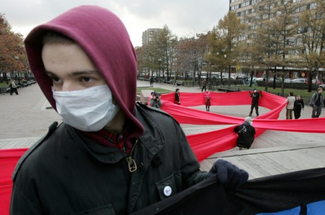 Russian FrontAIDS activists display a large red ribbon, a sign of support for people livin