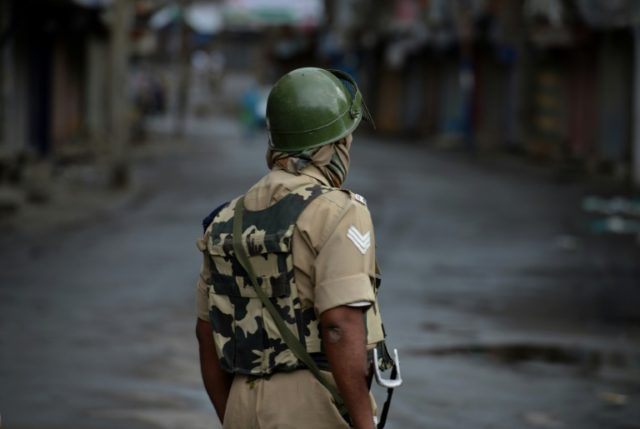 An Indian paramilitary trooper stands guard during a curfew in Sringar, Indian Kashmir, on