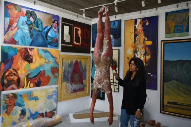 Sameera Raja explains an art work at her Canvass Gallery in Karachi