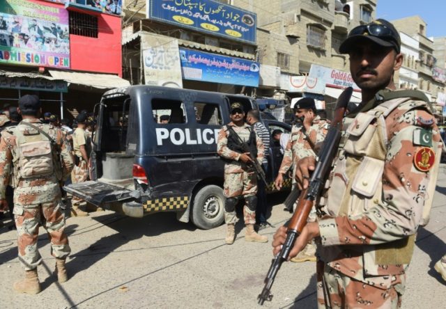 Pakistani security personnel gather around a police van in Karachi
