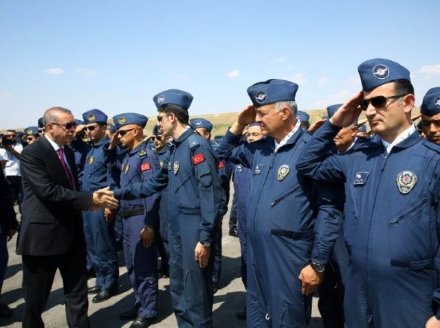 Turkish President Recep Tayyip Erdogan (L) shakes hands with security forces during his vi
