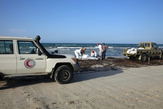 Libyan Red Crescent personnel retrieve the body of a migrant that washed up on a Libyan be