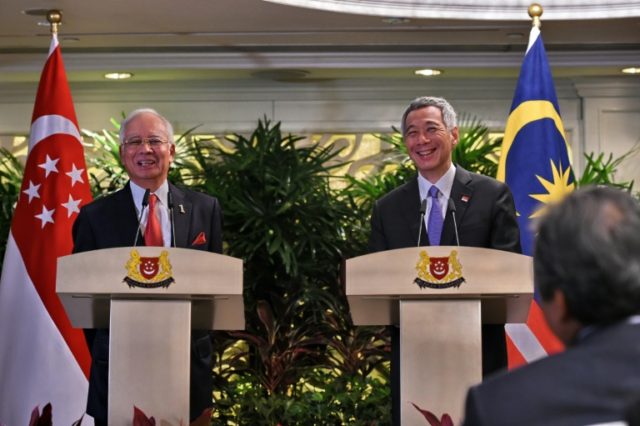 The signing was overseen by Malaysian Prime Minister Najib Razak (L) and his Singapore cou