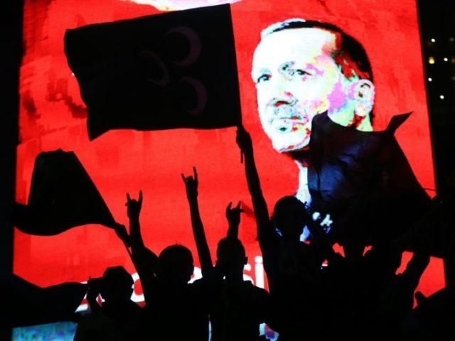 Supporters stands in front of a screen displaying a portrait of Turkish President Recep Ta