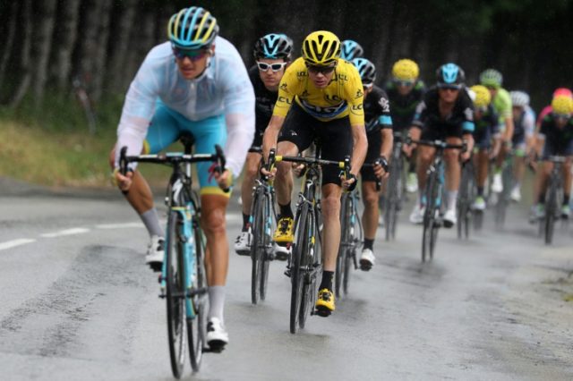 Britain's Chris Froome (3rd L), wearing the overall leader's yellow jersey, rides in the r